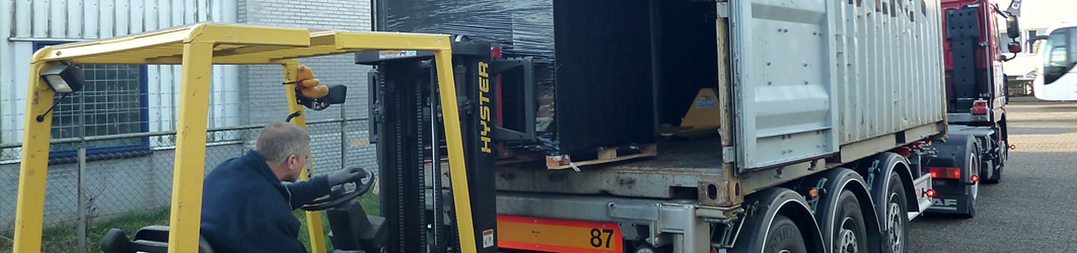 Een container wordt geladen bij het magazijn